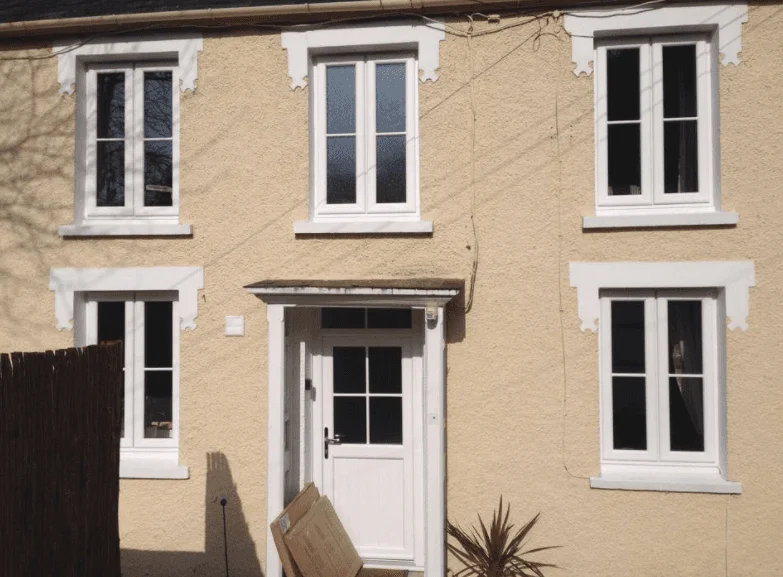 White windows and entrance door on a cream house, from the original PK Windows gallery
